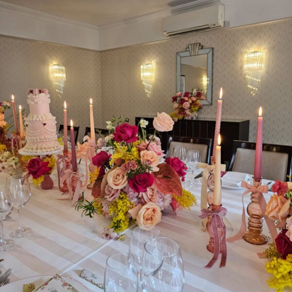 Bright and intimate wedding tablescape at The Lansdowne Club featuring yellow mimosa, Pink Floyd roses, peach and pale pink Sweet Avalanche roses, coral charm roses, pink Columbia hydrangea, and pink anthurium.