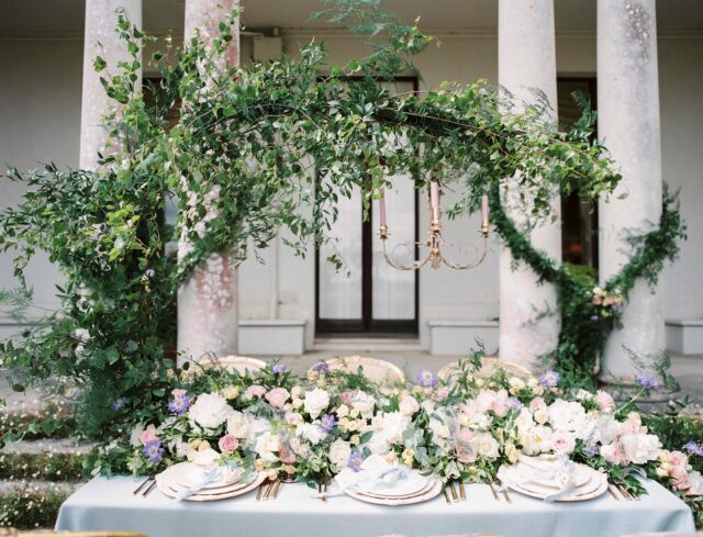 A celebration of soft elegance and natural beauty — this wedding tablescape is a delicate dance of pastel florals and lush foliage. Featuring lemon spray roses, sweet avalanche roses, white hydrangeas, and the whimsical charm of lilac scabiosa, every bloom is carefully chosen to create a romantic, fresh, and timeless atmosphere.