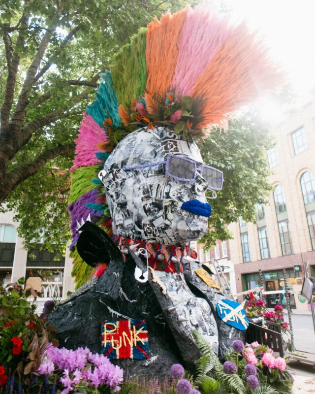 Chelsea goes punk!
We’ve created not one, but two floral Chelsea Punks this year for “Flowers in Fashion” theme. You’ll find this rebellious beauty on King’s Road as part of Chelsea in Bloom, while our second punk is turning heads at the Chelsea Flower Show.
Crafted with care and attitude, this piece features a skull collaged in Sex Pistols and Vivienne Westwood articles, a jacket of preserved black-sprayed leaves, and a Mohican made from pampas grass, palm leaves, anthurium and more.
Even the badges are made from preserved flowers!
Catch our floral rebel in the wild until Sunday. @polarblackevents Metal work: @juliancarterdesign 
Photography : @musemotionpictures